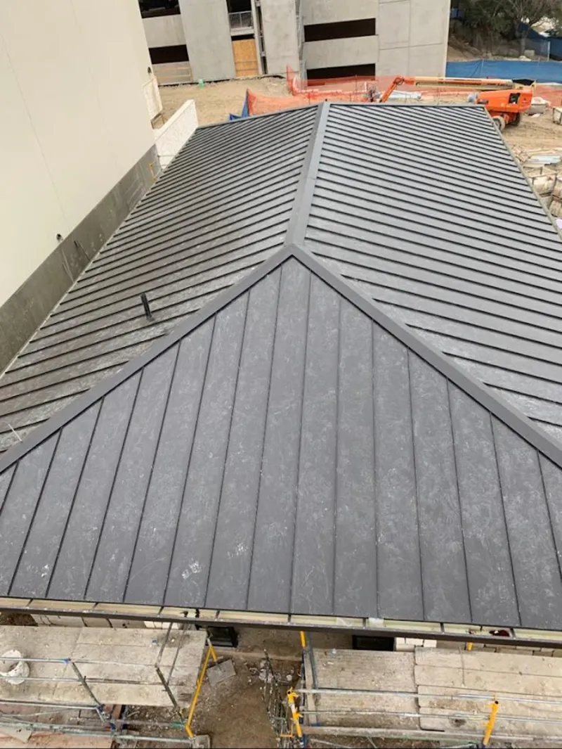 Commercial metal roof construction with crane equipment in Hernando